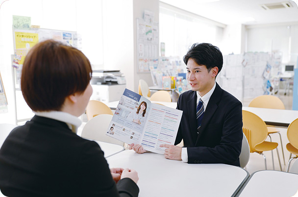 写真:向かい合って座っているふたり。スーツを着た男性が資料をみせながら説明している様子