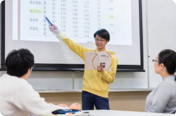 写真:スライドを指差しながら説明している学生と発表を聞く人たち
